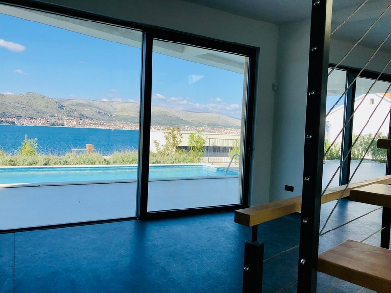 Pièce avec façade vitrée et escalier avec vue sur la piscine et la baie