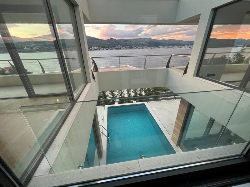 Vue à travers le garde-corps en verre sur la piscine et la baie
