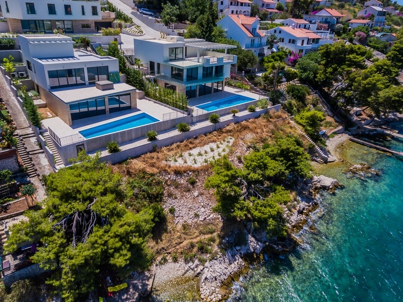 Vue aérienne de deux villas avec piscines directement au-dessus de l'eau