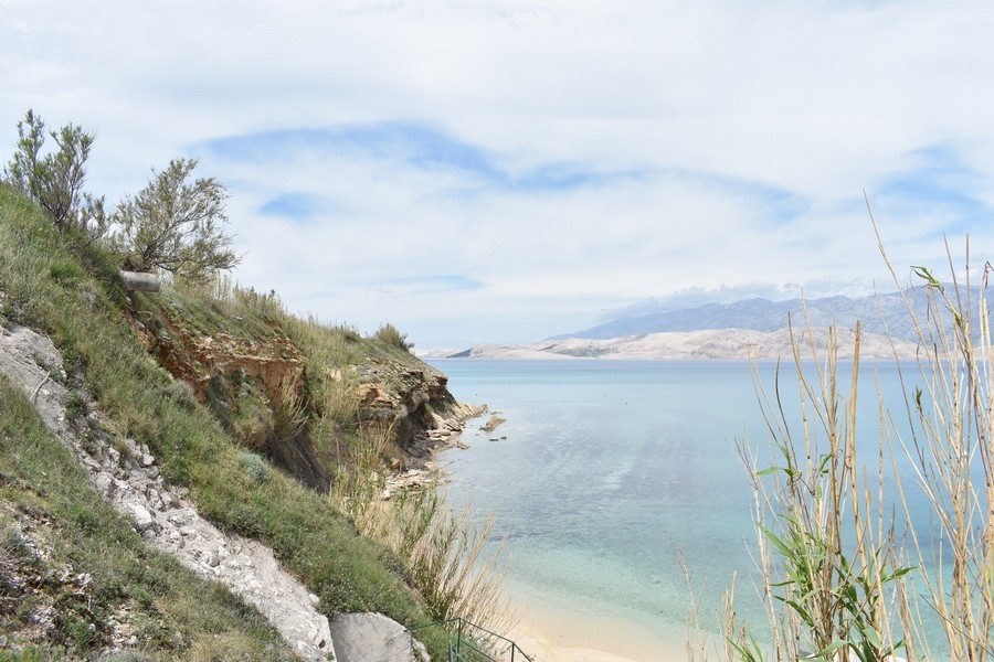 Pente raide au-dessus de l'eau turquoise avec plage en contrebas