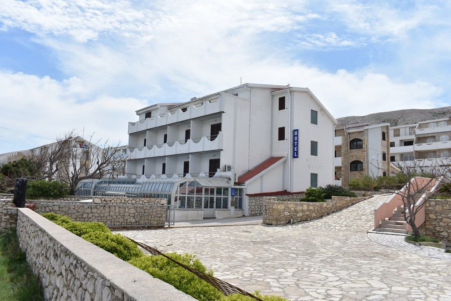 Bâtiment hôtelier blanc avec jardin d'hiver et mur en pierre naturelle