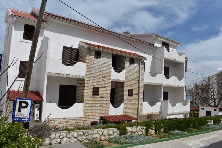Bâtiment à façade en pierre naturelle et volets battants au bord de la rue