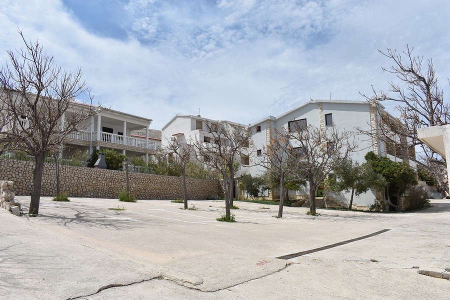 Immeubles d'appartements blancs derrière le mur en pierre naturelle près du parking