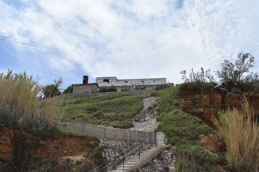 Escalier montant la pente jusqu'au bâtiment sur la butte