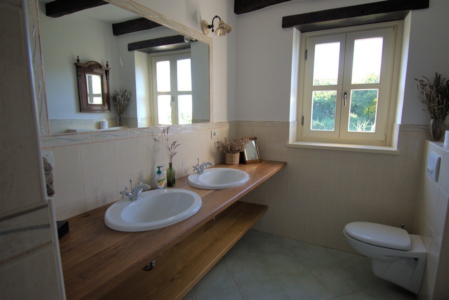 Salle de bains avec deux lavabos sur un long plan en bois