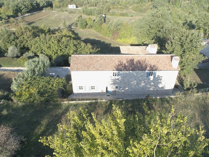 Vue aérienne de la maison en pierre avec toit en tuiles dans la verdure