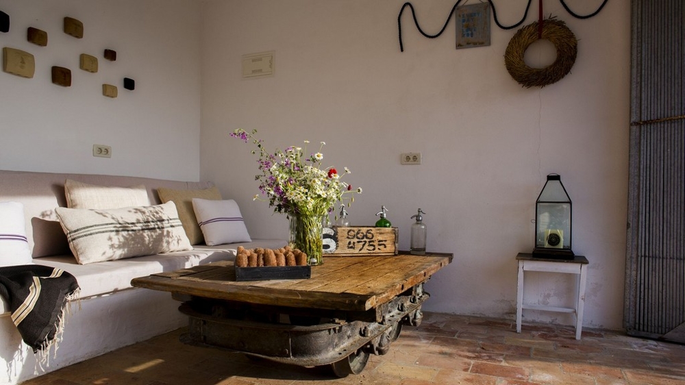 Banc maçonné avec coussins et table en bois rustique