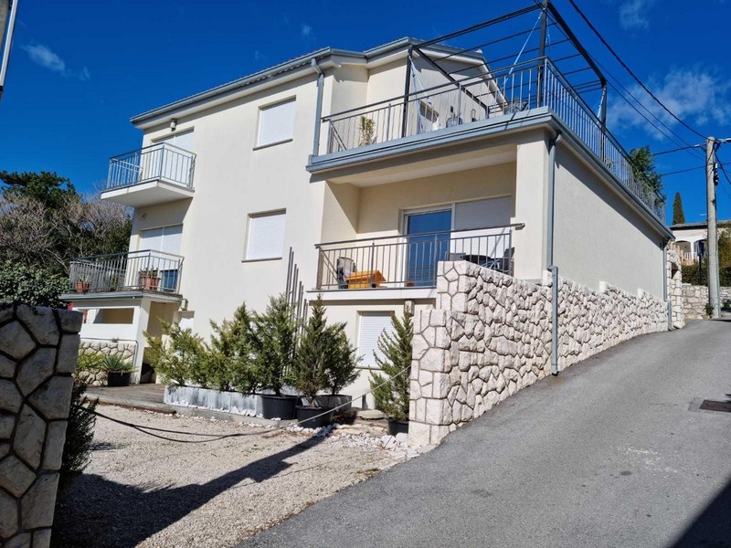 Immeuble d'appartements clair avec balcons au bord de la route