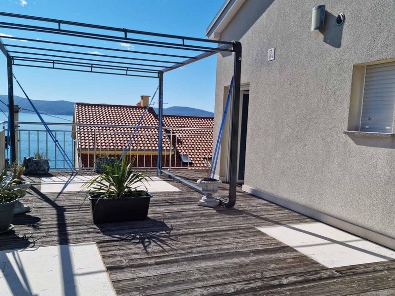 Terrasse en bois avec structure de pergola et vue sur la baie