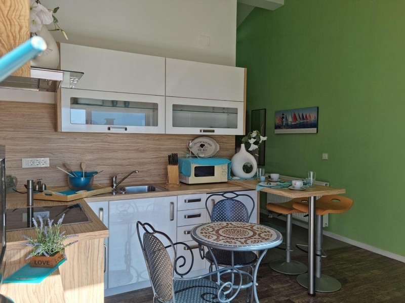 Cuisine linéaire avec mur vert et table de bistrot ronde