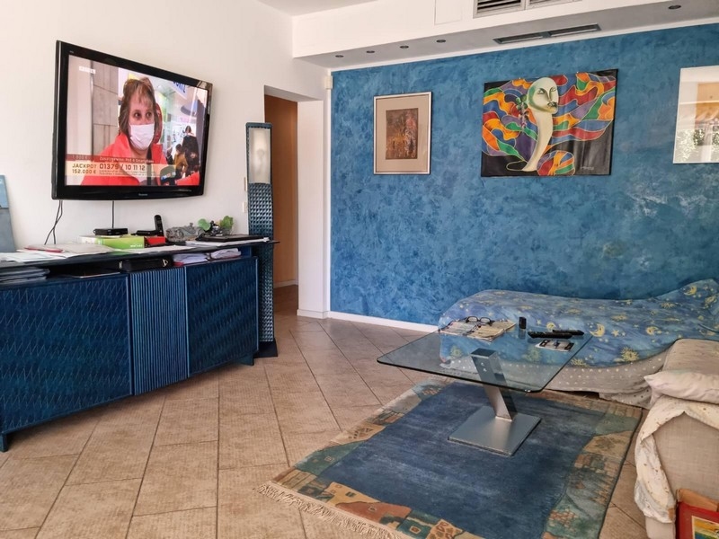 Séjour avec mur bleu et tableaux au-dessus du canapé