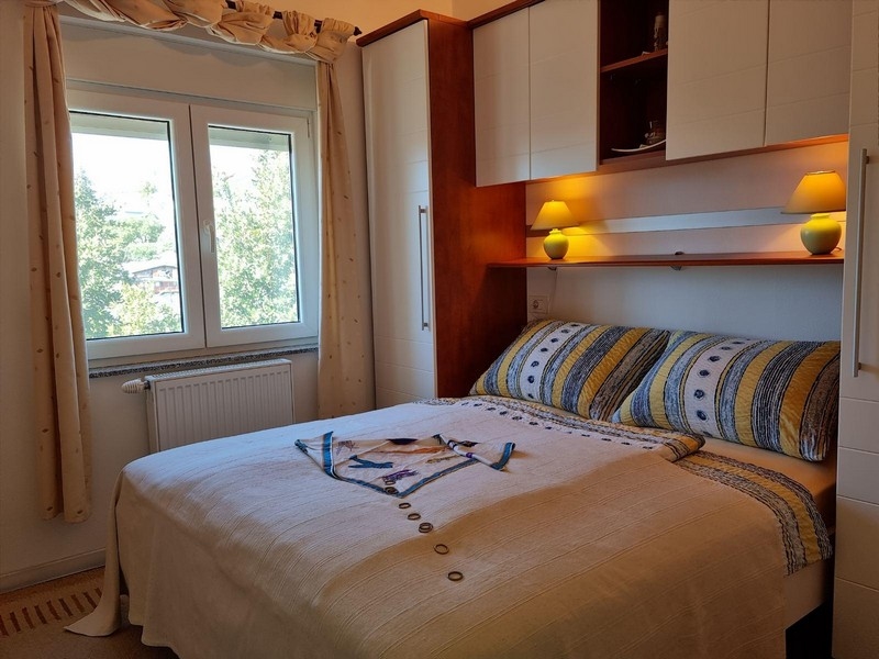Chambre avec placard en surplomb et fenêtre donnant sur la verdure