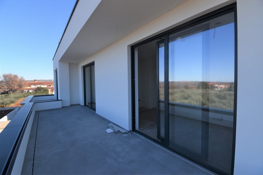 Longue terrasse avec portes coulissantes et vue sur la verdure