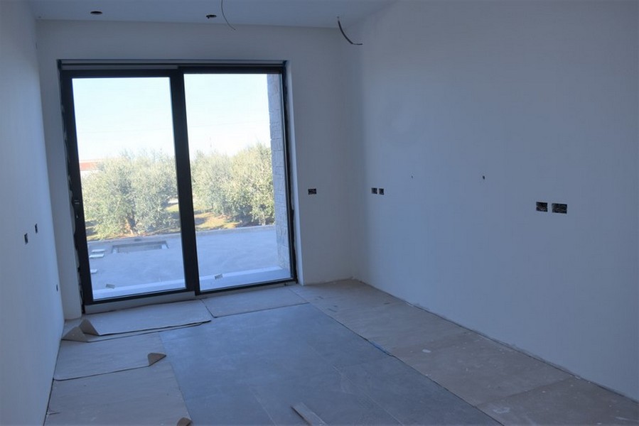 Pièce inachevée avec porte de terrasse donnant sur l'oliveraie