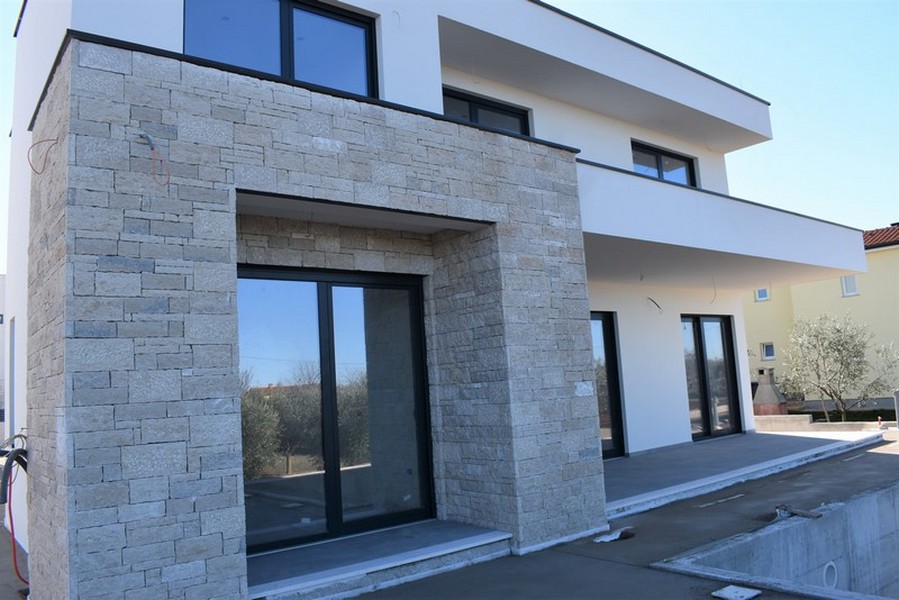 Façade de la maison avec revêtement en pierre naturelle autour de l'entrée
