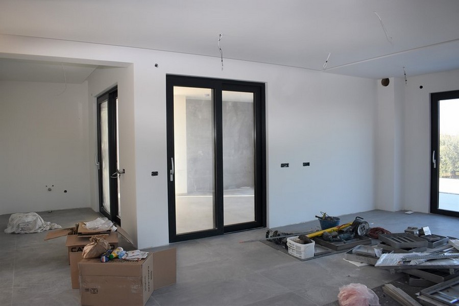 Séjour inachevé avec porte de terrasse et matériaux de construction