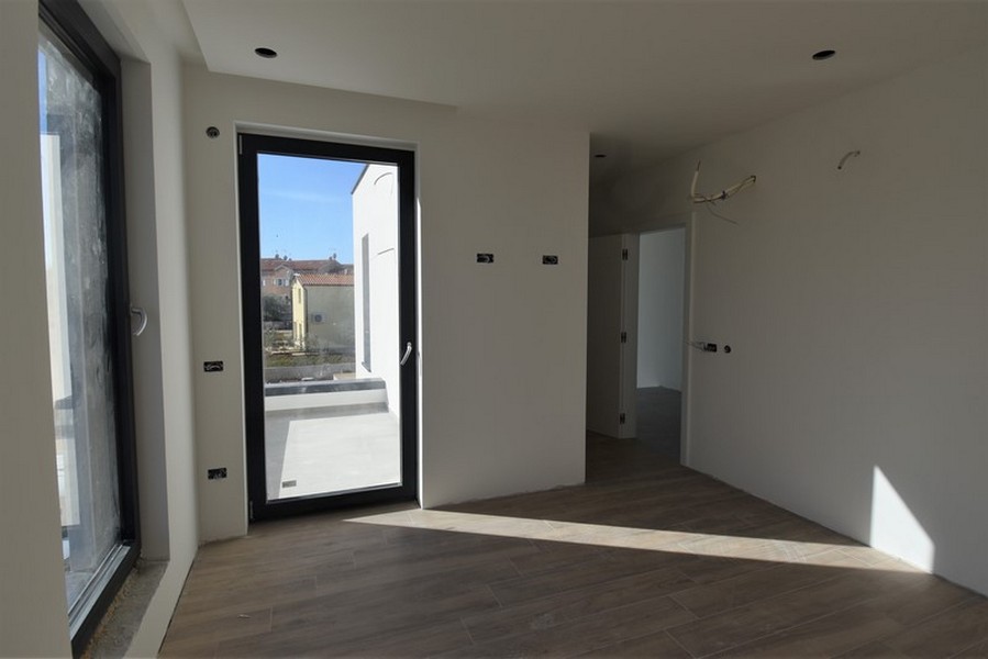 Pièce avec porte de balcon étroite et couloir attenant