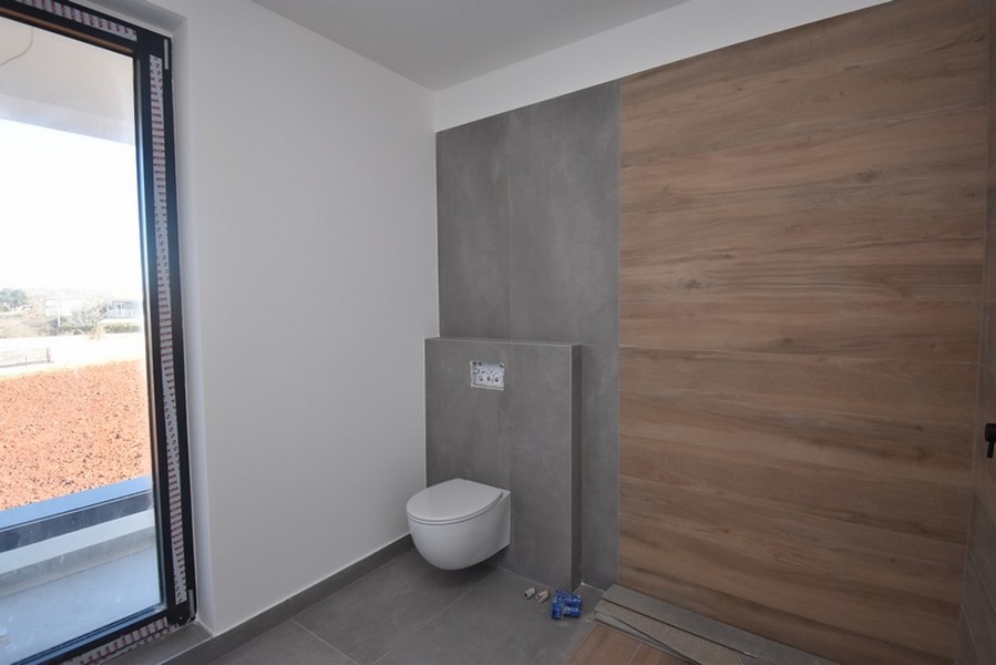 Salle de bains avec mur effet bois et fenêtre du sol au plafond