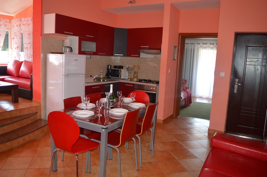 Cuisine rouge avec table à manger dressée et chaises rouges