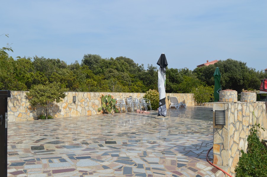 Grande terrasse en pierre avec mur et cactus