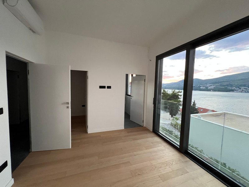 Pièce avec parquet et fenêtre du sol au plafond donnant sur l'eau