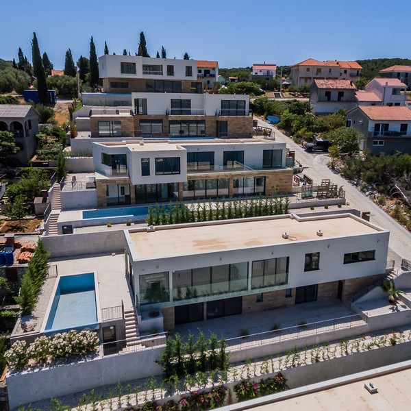 Vue aérienne de plusieurs villas avec piscines à flanc de colline