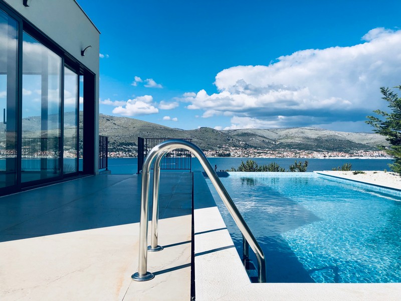 Échelle de piscine et bord à débordement avec vue sur le village et les montagnes