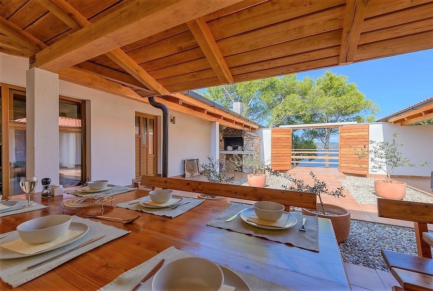Terrasse couverte avec table sous un plafond en bois