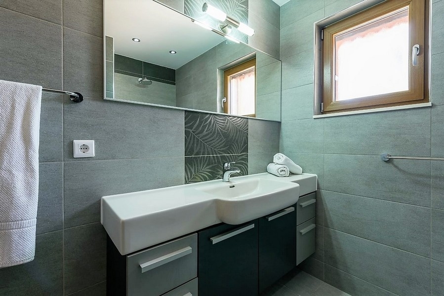 Salle de bains avec double vasque et miroir