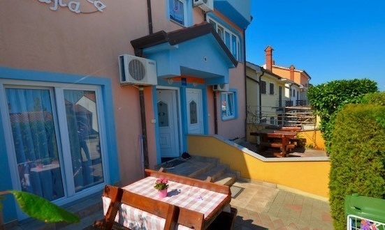 Façade de la maison en bande avec table à manger extérieure à Novigrad