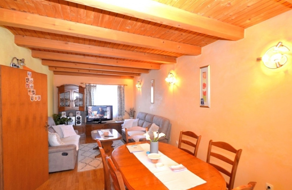 Salon avec poutres en bois et canapé dans la maison en bande de Novigrad