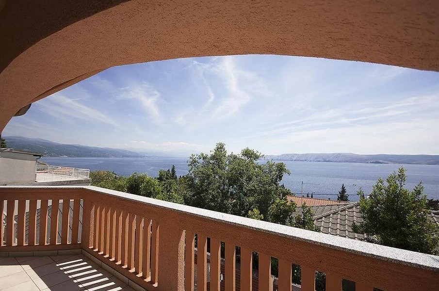 Vue du balcon voûté par-dessus les arbres sur la mer