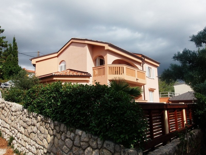 Maison abricot avec balcon en arc au-dessus du mur en pierre naturelle