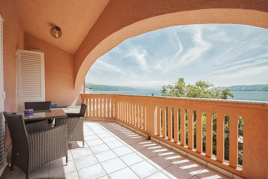 Loggia avec arc en plein cintre et balustrade au-dessus de la baie