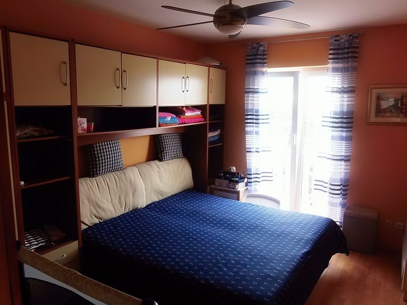 Chambre avec placard de dessus de lit et ventilateur de plafond