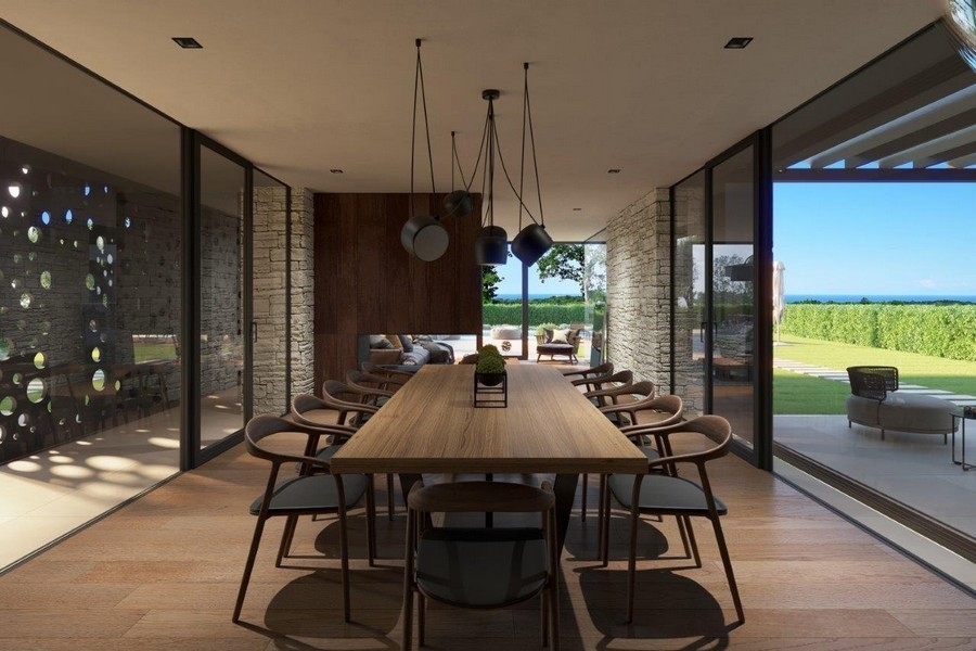 Visualisation de la longue table à manger devant la façade vitrée