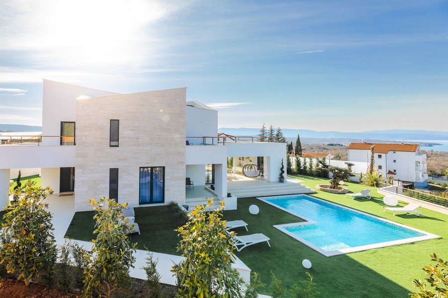 Villa claire avec piscine et pelouse au-dessus de la baie