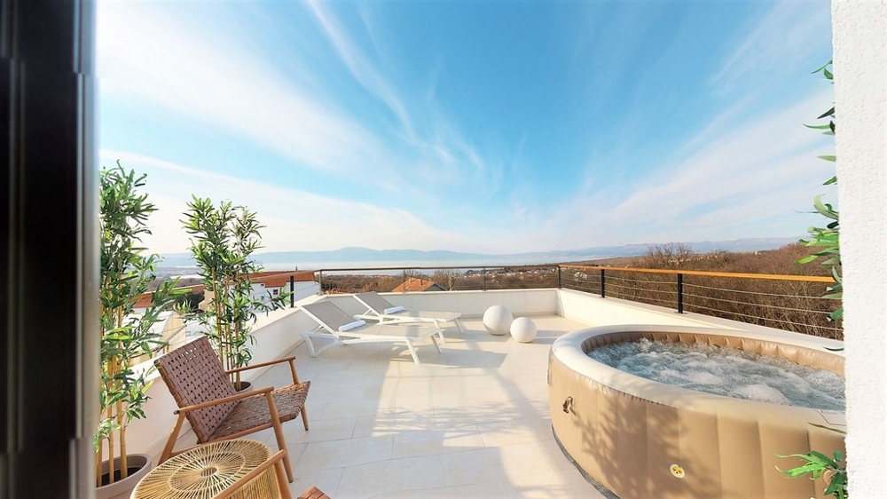 Toit-terrasse avec jacuzzi et transats au-dessus de la baie