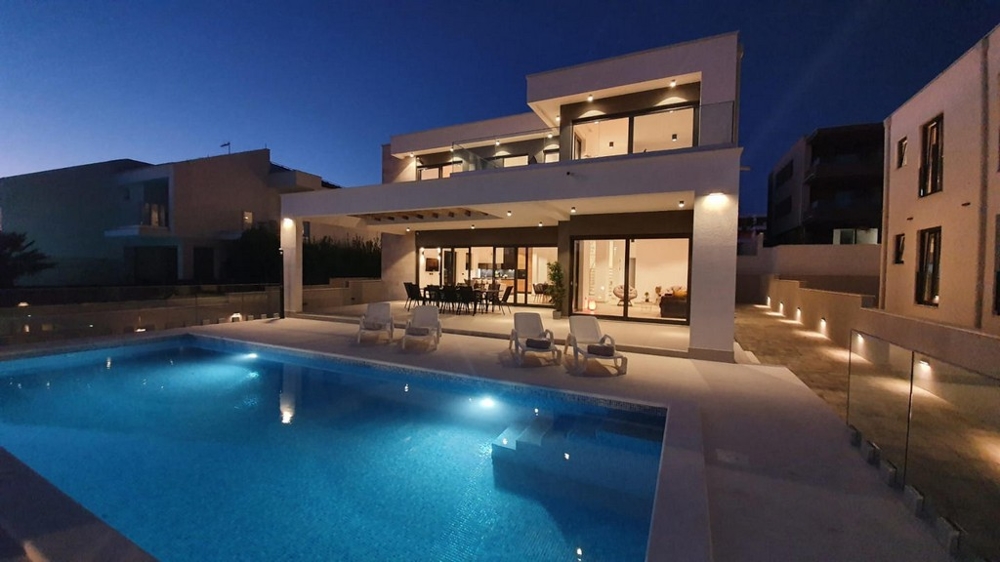 Piscine éclairée devant la villa au crépuscule