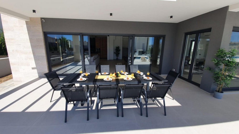 Terrasse moderne avec coin repas couvert.