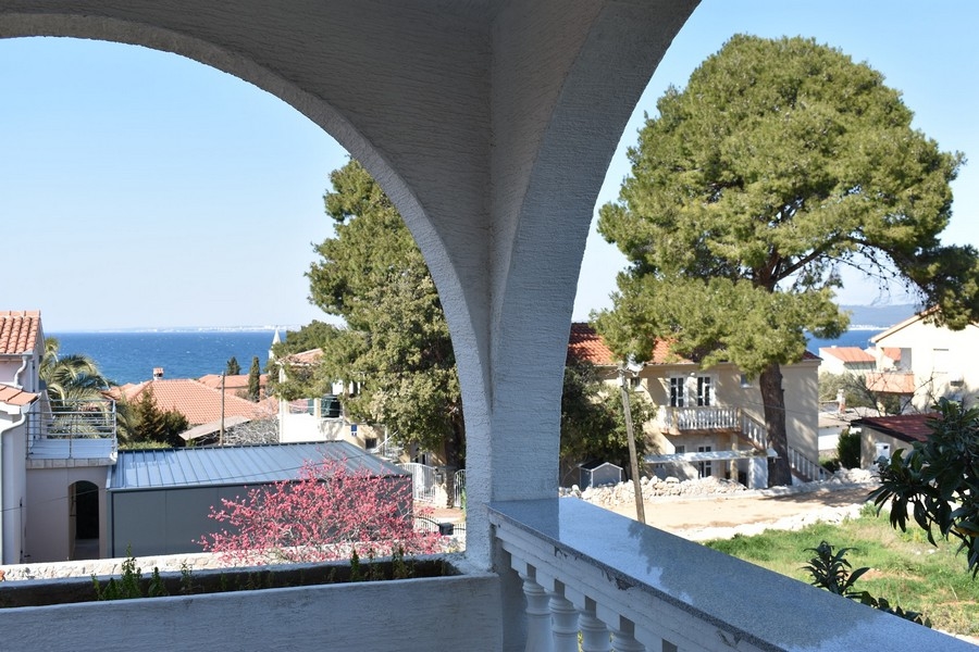 Vue à travers l'arc de la loggia sur la baie et les maisons voisines