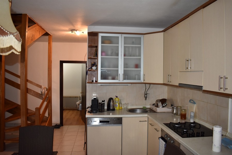 Cuisine crème avec escalier en bois à l'arrière-plan