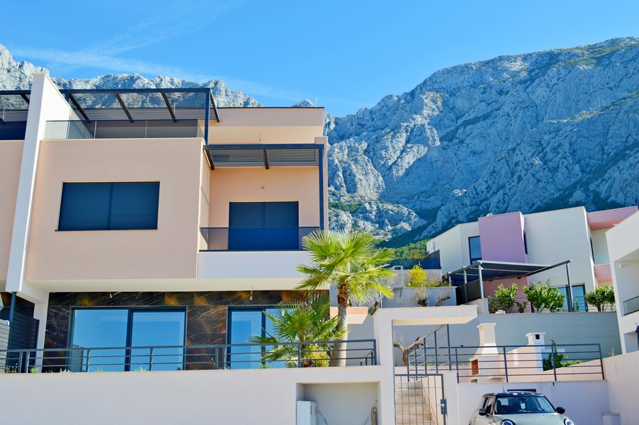 Maison jumelée avec palmier devant la toile de fond du Biokovo