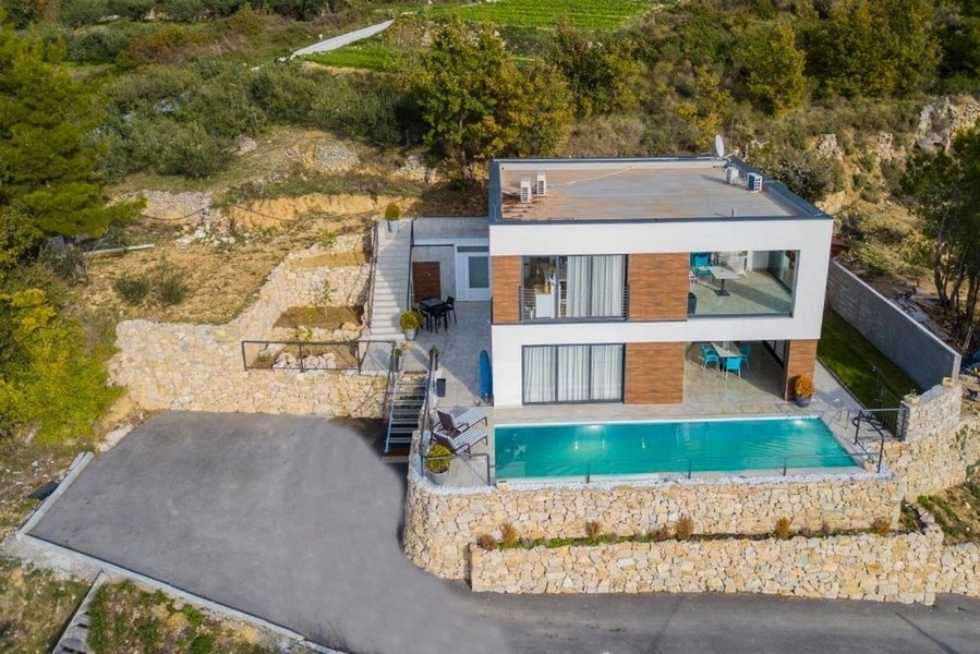 Vue aérienne de la villa avec piscine au-dessus du mur en pierre sèche