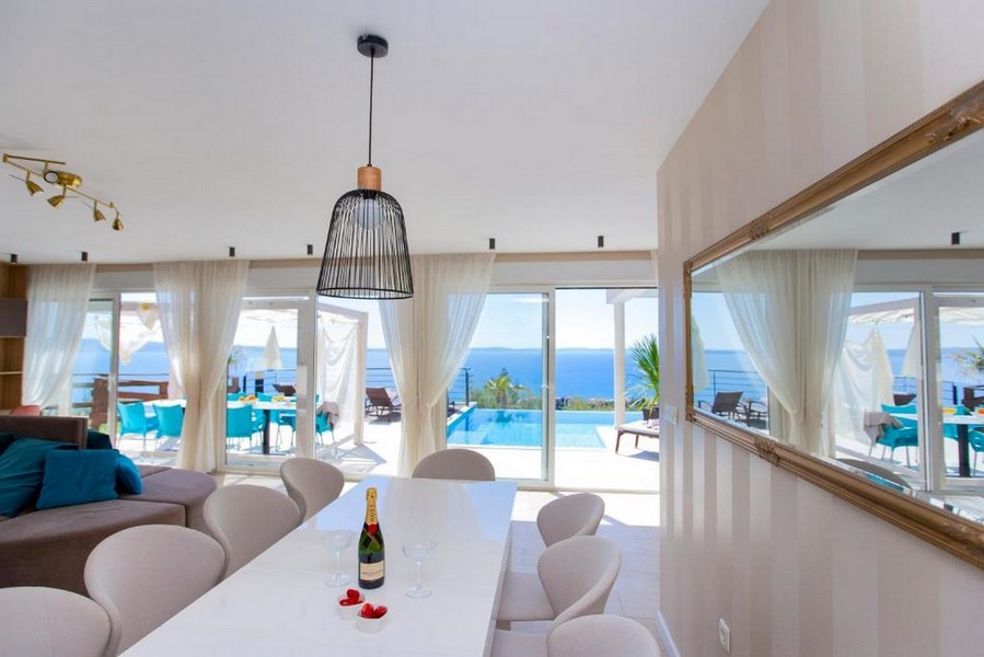 Table à manger devant la baie vitrée avec piscine derrière