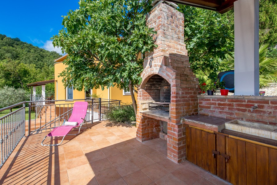 Terrasse avec barbecue maçonné et bain de soleil
