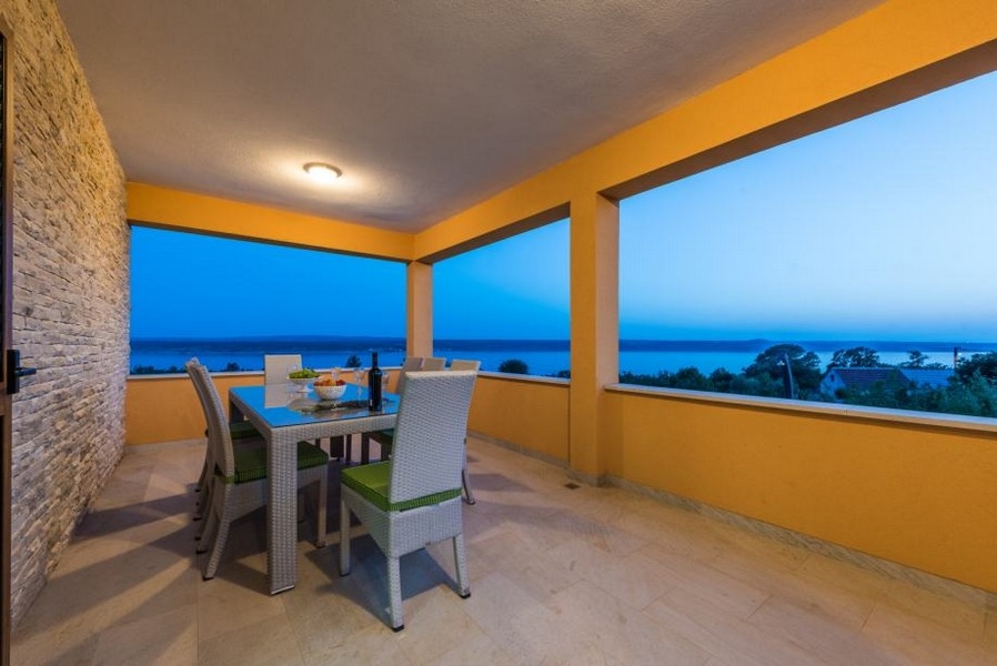 Terrasse couverte avec table dressée et vue sur la mer