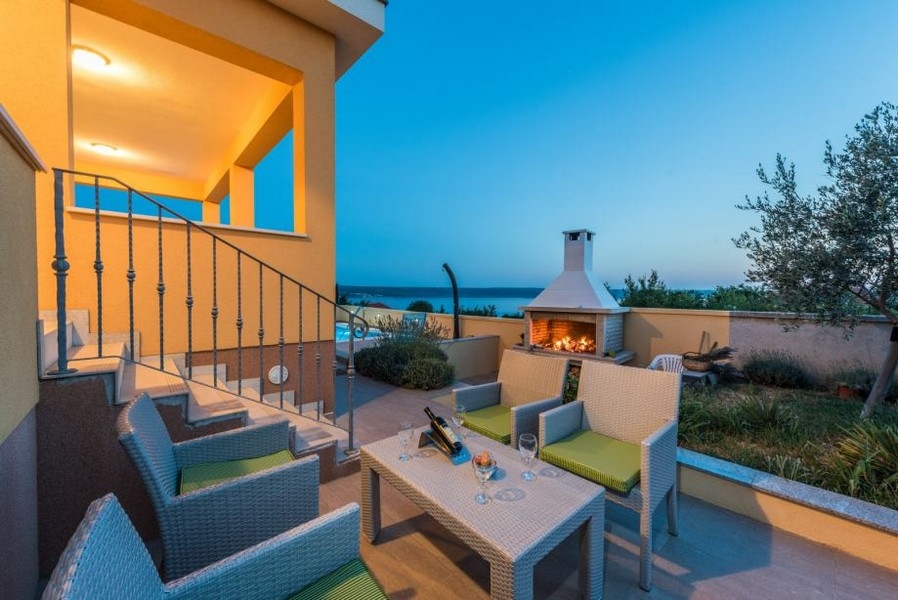 Coin salon devant la cheminée allumée sur la terrasse
