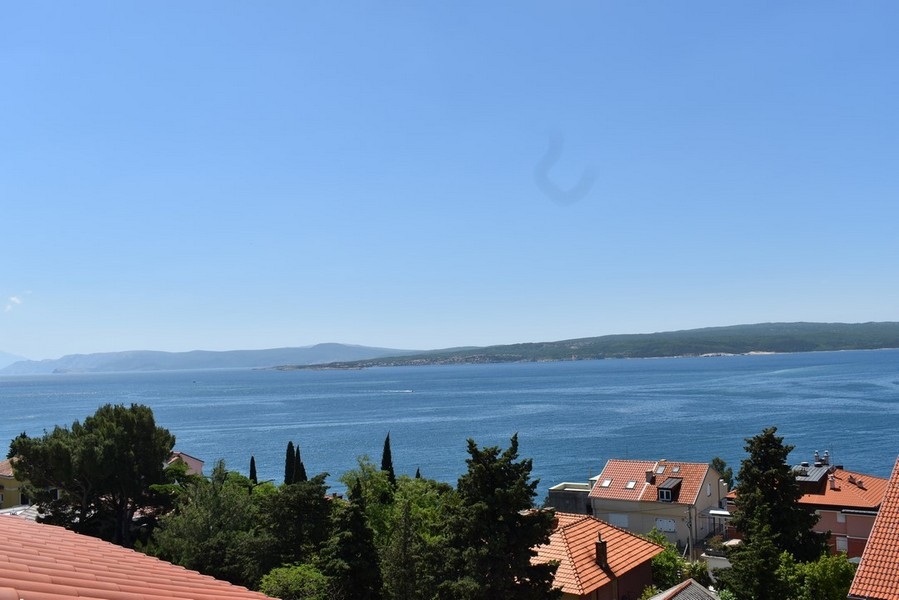 Vue au-dessus des toits en tuiles et des cyprès sur la baie