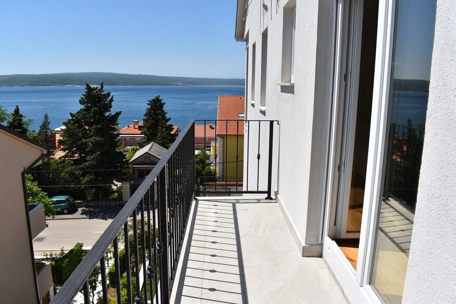 Balcon étroit avec vue au-dessus des cyprès sur la baie